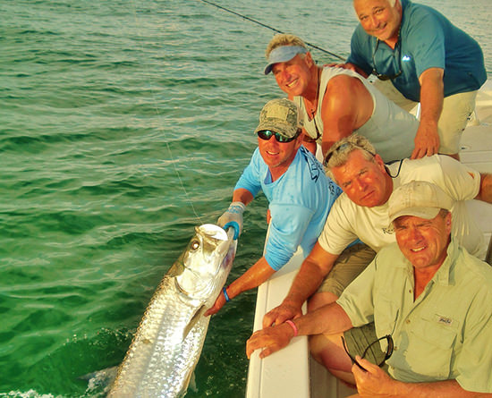 A charter group holding a huge tarpon caught with Capt. Jesse in Boca Grande.